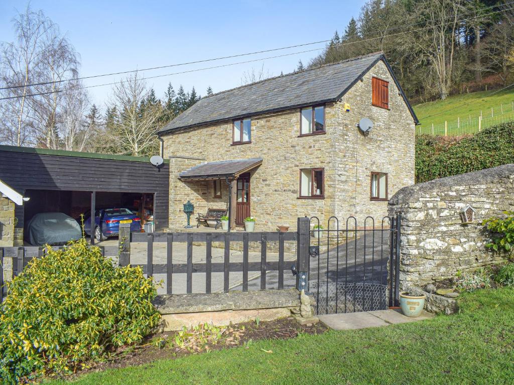 a brick house with a fence in front of it at Border View in Kington