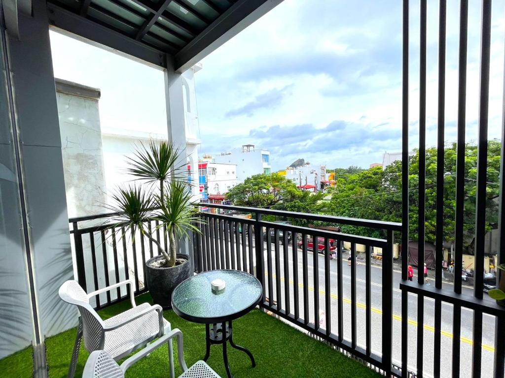 墾丁的住宿－35點5旅店 ，设有一个配有桌椅并享有美景的阳台。