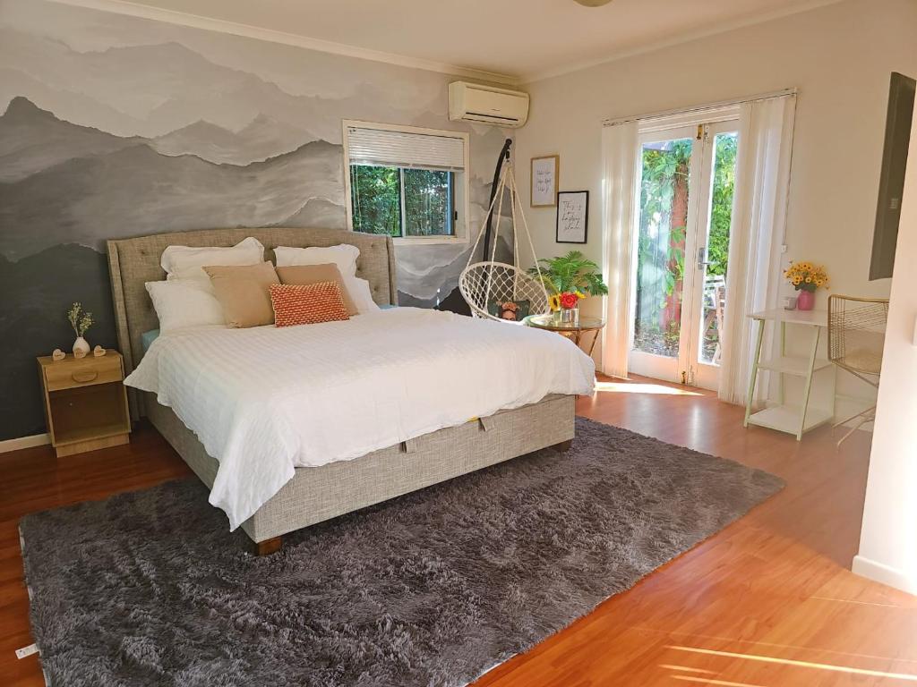 a bedroom with a large white bed and a rug at 11 chartwell in Brisbane