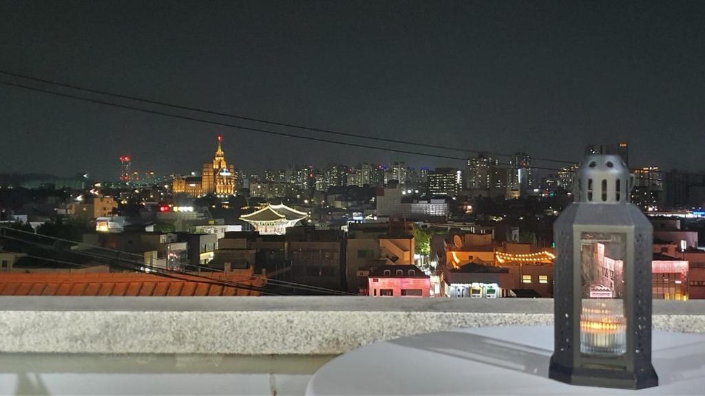 una botella en una cornisa con vistas a la ciudad en The Stair House en Suwon