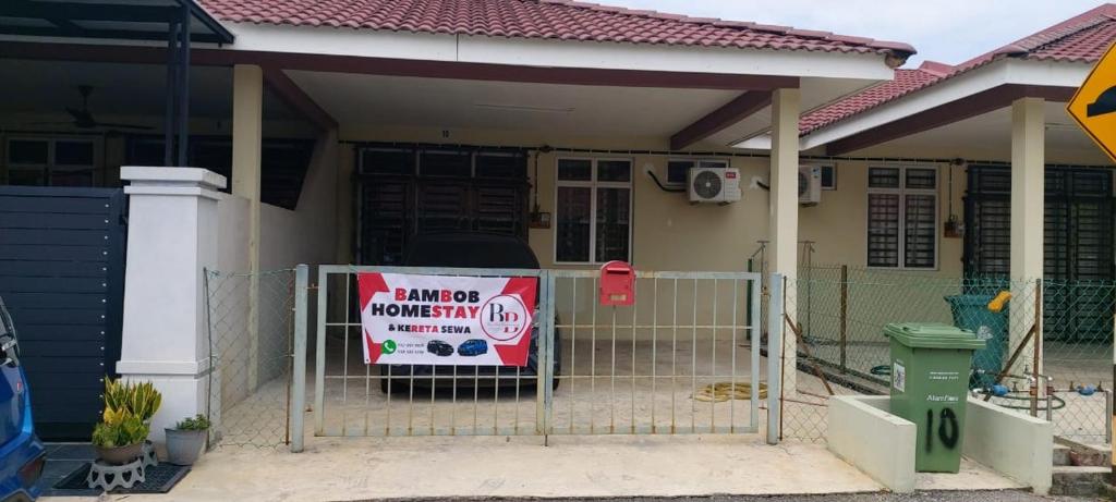 a house with a sign in front of it at Bambob Homestay and Car Rental in Gambang