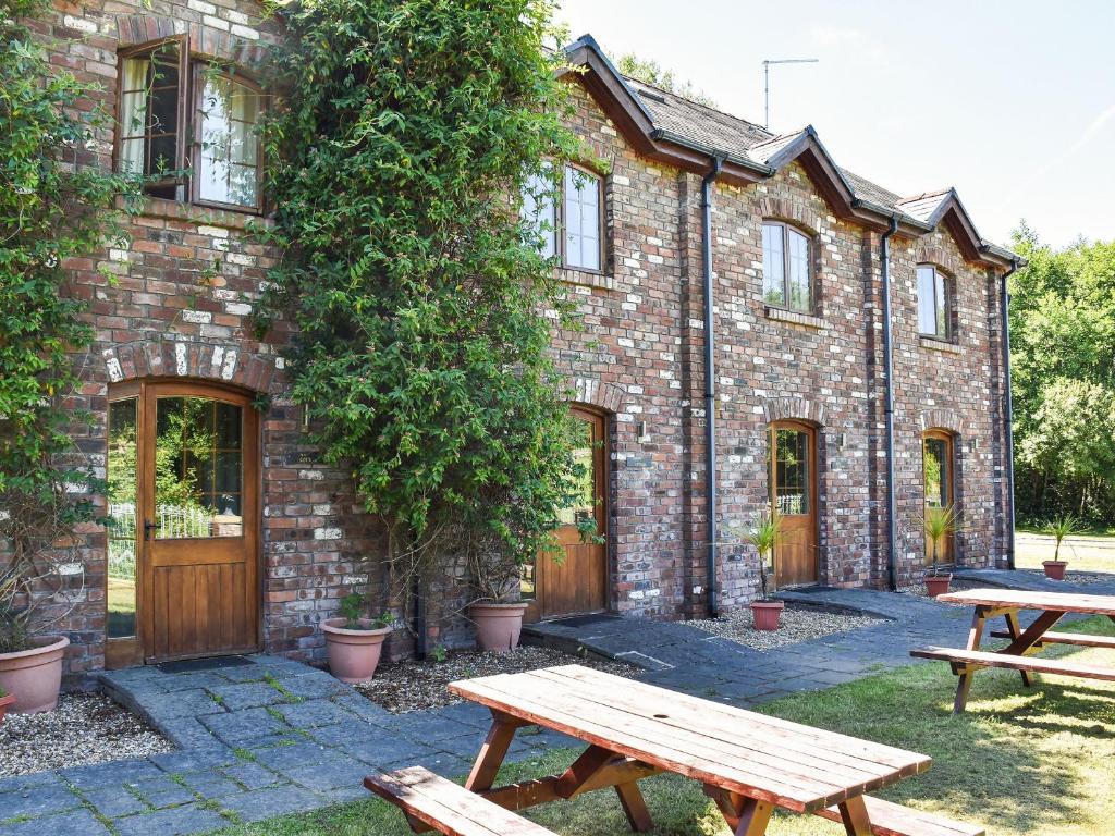 a brick building with two picnic tables in front of it at Lily Cottage - Uk40101 in Dunvant