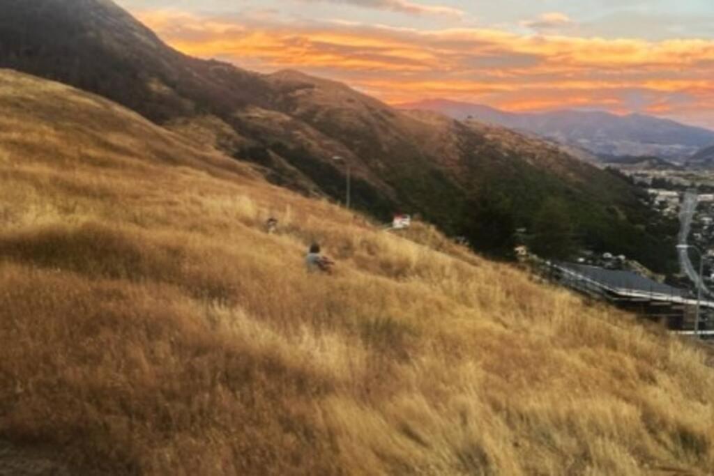 eine Person, die auf einem Hügel mit Gras steht in der Unterkunft Views on Florence in Queenstown