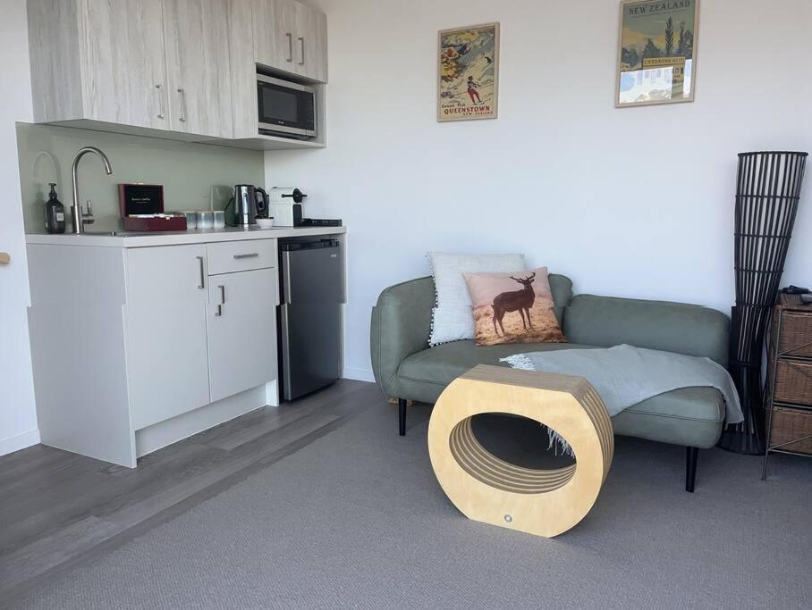 ein Wohnzimmer mit einer Couch und einem Tisch in der Unterkunft Views on Florence in Queenstown