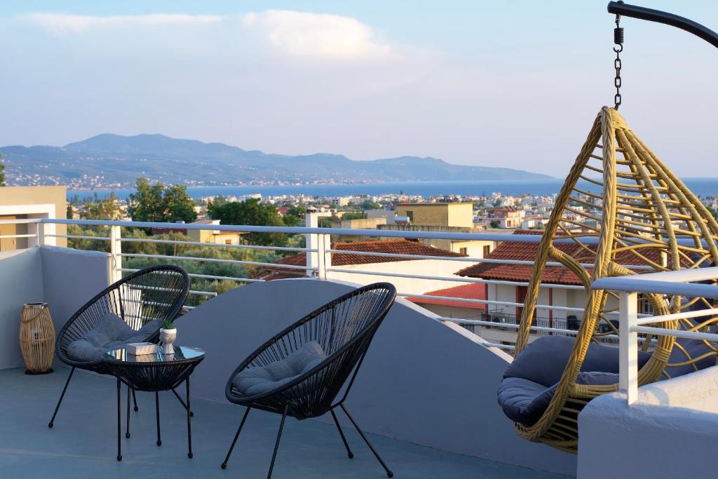 een patio met 2 stoelen en een tafel op een dak bij Kiriakos Apartment in Kalamata