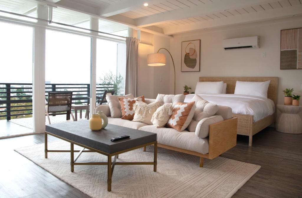 a living room with a bed and a white couch at Hollywood Hills Hotel in Los Angeles
