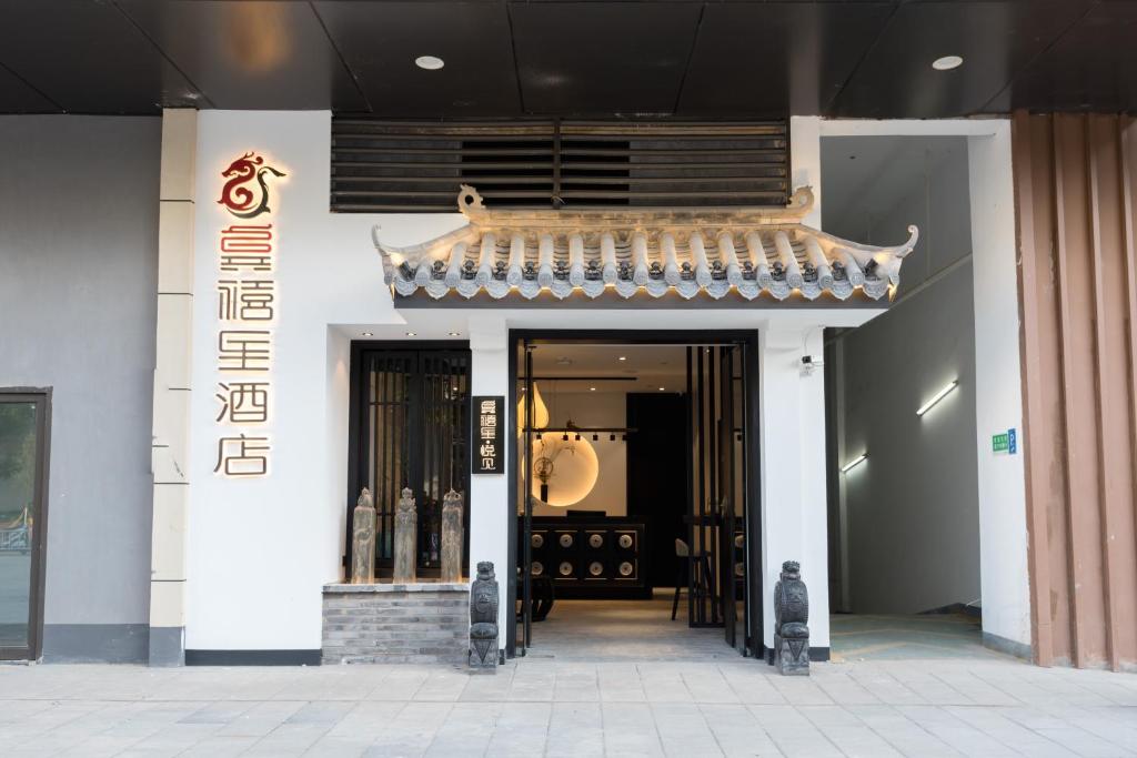 einen Eingang zu einem Gebäude mit einem chinesischen Dach in der Unterkunft Gongxili - Yuejian Hotel in Kunming