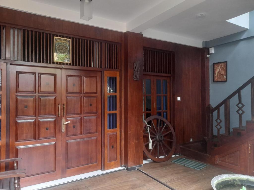 Habitación con puertas de madera y una rueda en la pared. en Chari Eco Bungalow, en Matara
