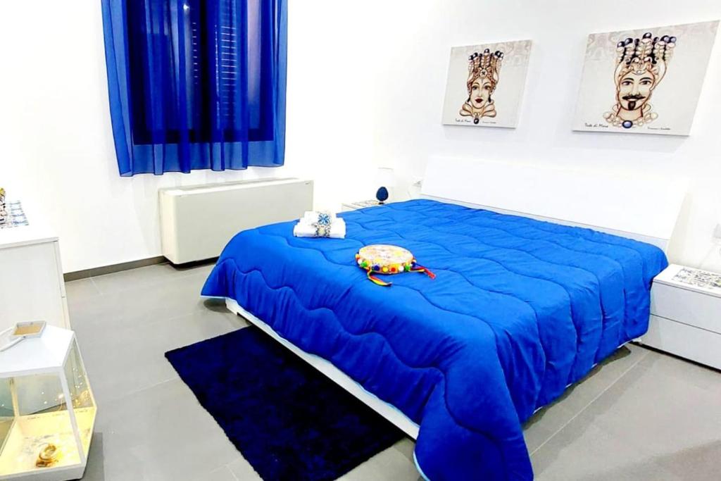 um quarto com uma cama azul com um bicho de peluche em Casa vacanze Sicilia bedda partinico em Partinico