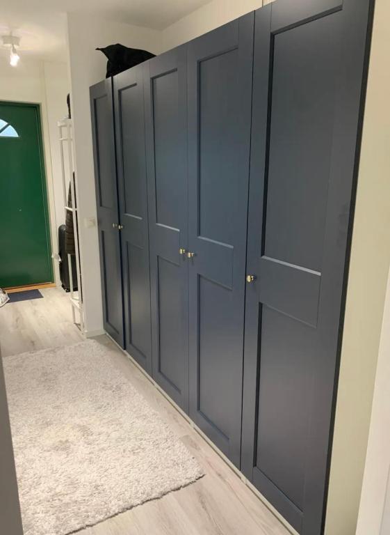 Cette chambre dispose de portes de placard noir et d'un tapis. dans l'établissement Glöm dina bekymmer i denna rymliga lägenhet, à Trollhättan