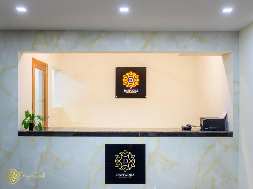 un mostrador con dos letreros en una pared en Daffodils Luxury Airport Suites, en Angamaly