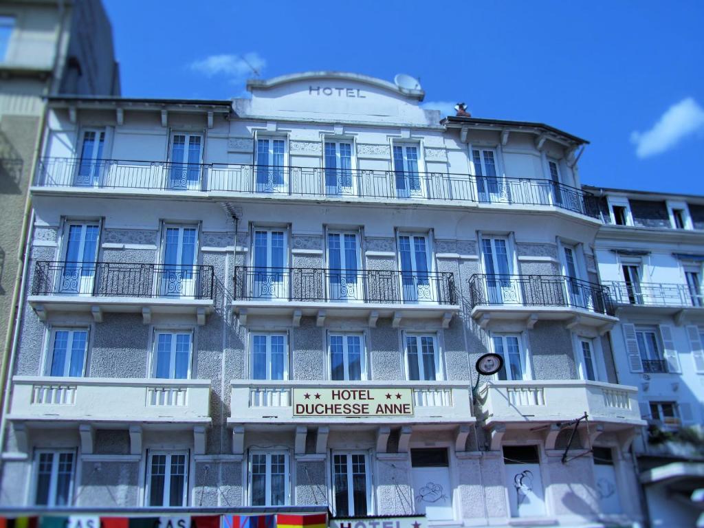a large white building with a large window at Hôtel Duchesse Anne in Lourdes