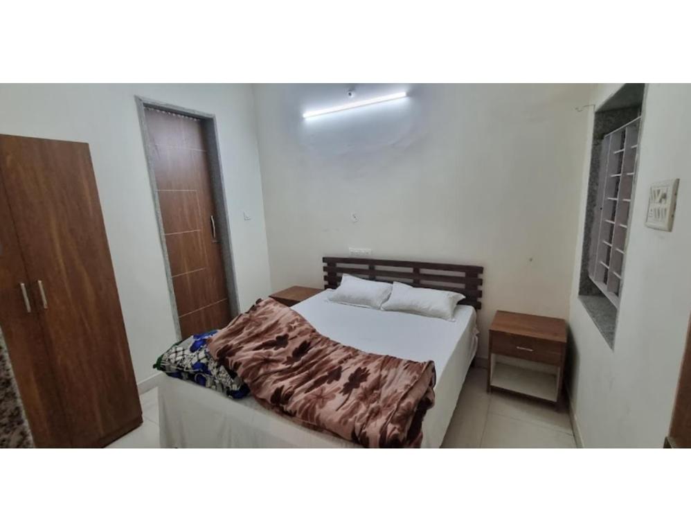 um quarto com uma cama e uma porta de madeira em Hotel Roopmati, Vidisha em Vidisha