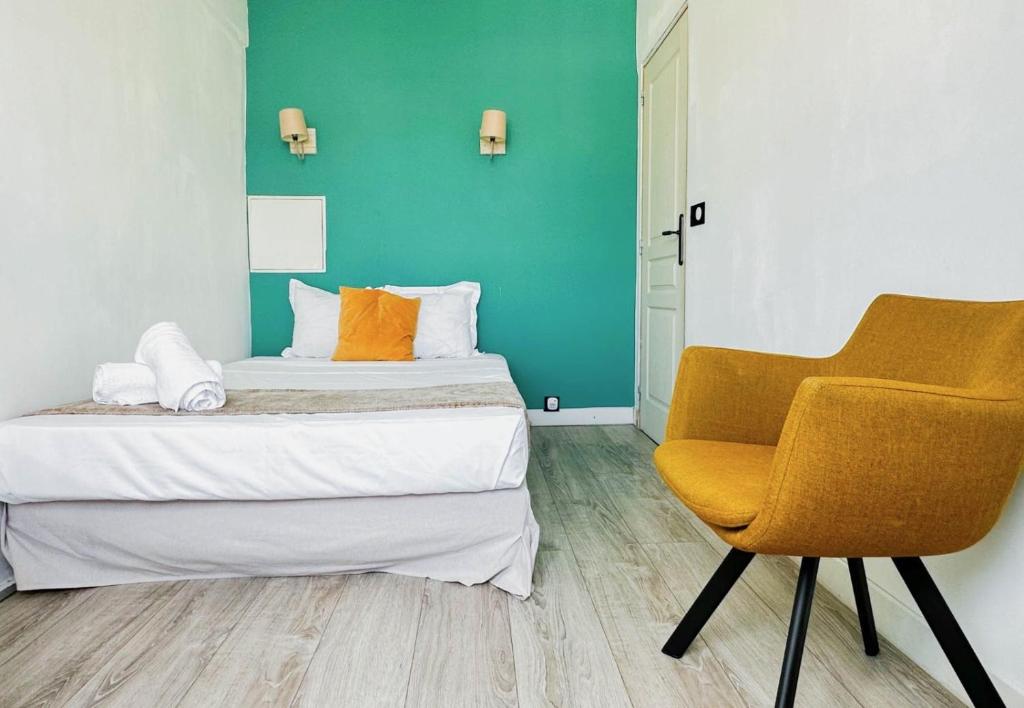 une chambre avec deux lits et une chaise dedans dans l'établissement Etoile des neiges 2 min du centre, à Annecy