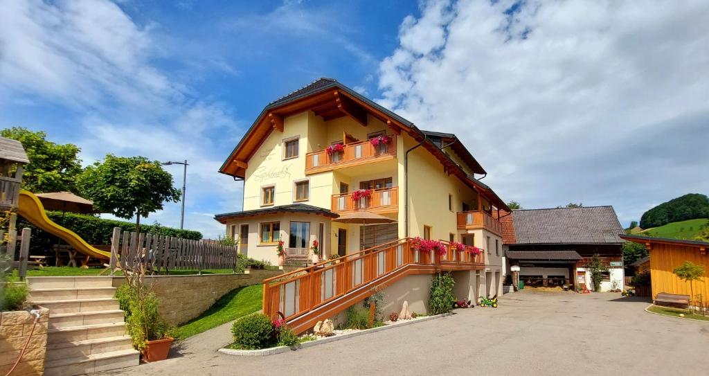 een huis met een balkon en een glijbaan bij Seyerlehnerhof in Maria Neustift