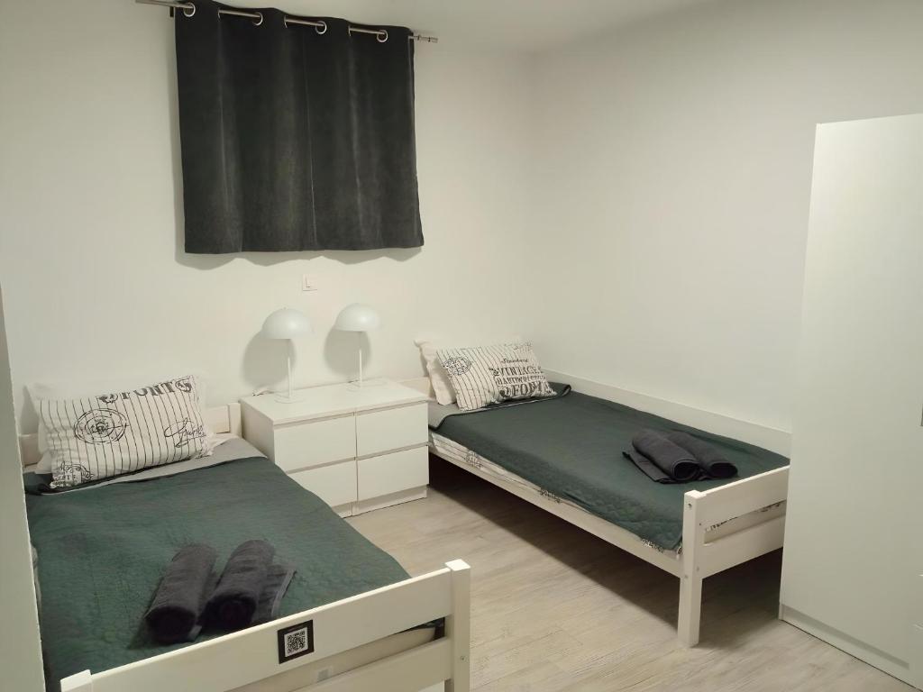 a bedroom with two beds and a black curtain at Apartment Patrik in Vabriga