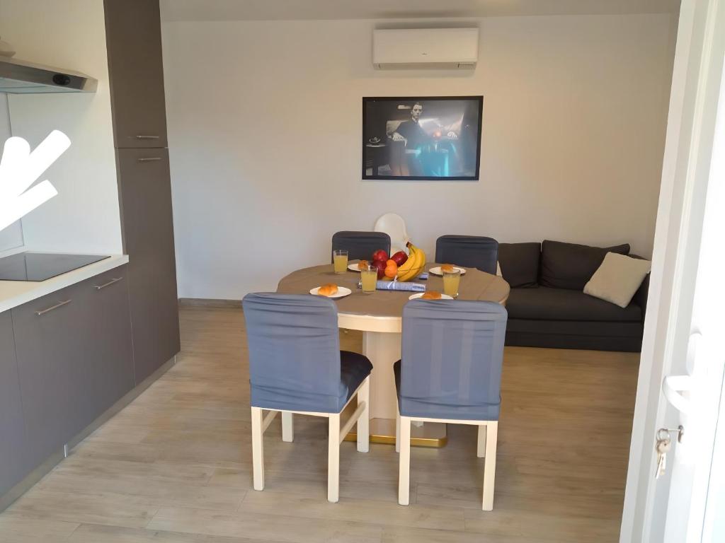 a small kitchen and living room with a table and chairs at Apartment Patrik in Vabriga