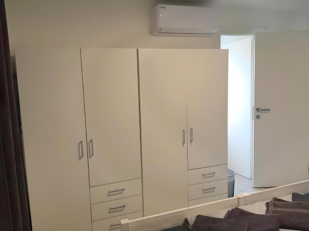 a white closet with white cabinets and a mirror at Apartment Patrik in Vabriga