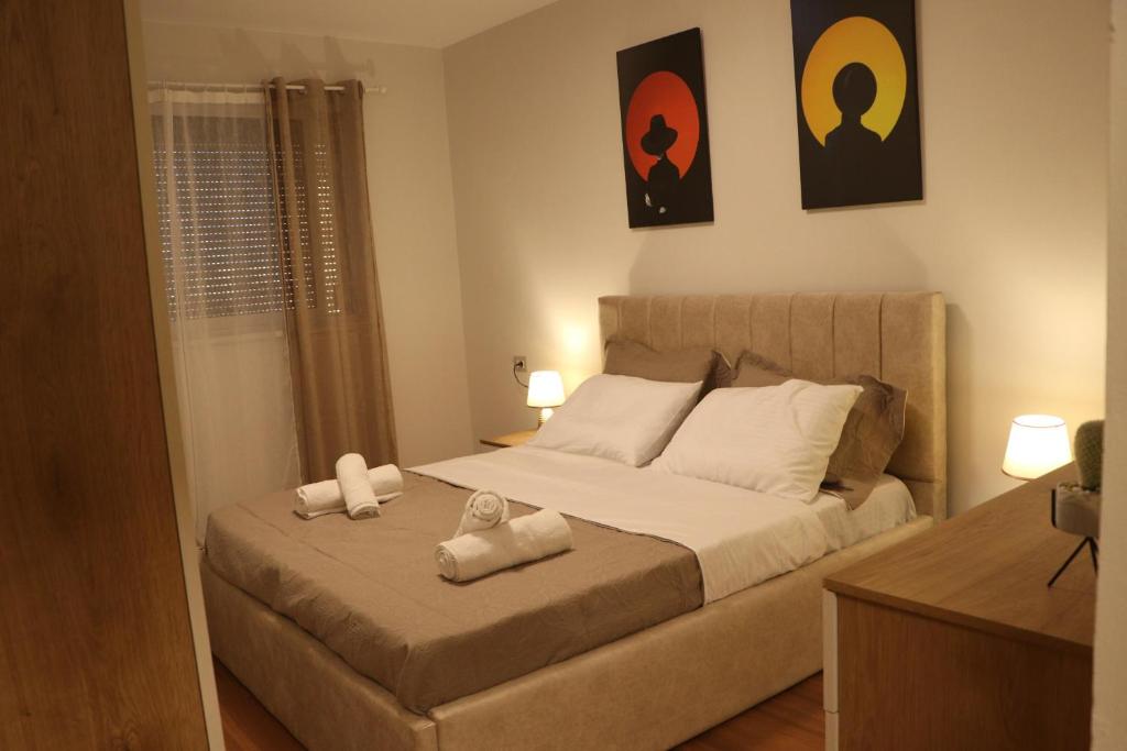1 dormitorio con 1 cama con 2 toallas en Pine Apartment Tirana, en Tirana