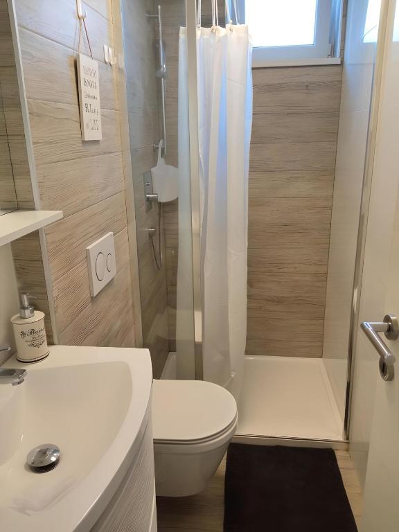 a bathroom with a white toilet and a shower at Apartment Patrik in Vabriga