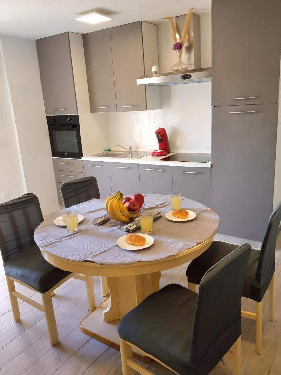 a kitchen with a table with plates of fruit on it at Apartment Patrik in Vabriga