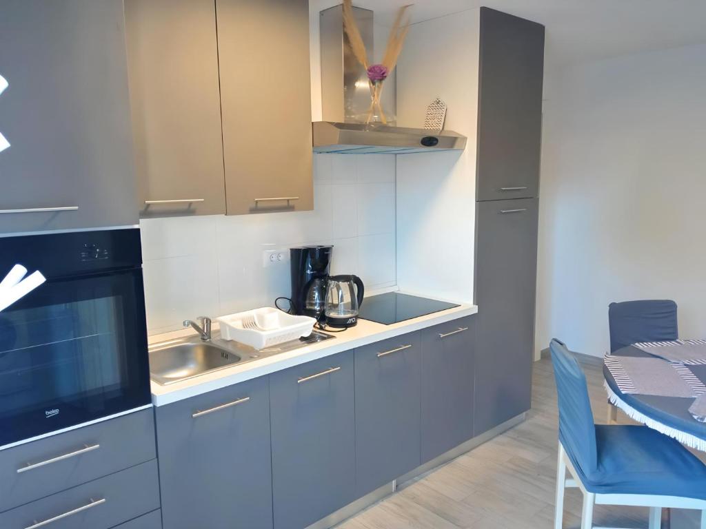 a kitchen with blue cabinets and a sink and a table at Apartment Patrik in Vabriga