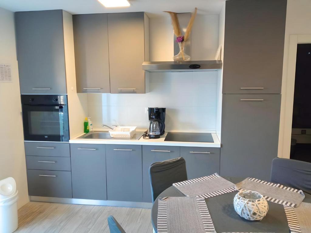 a kitchen with blue cabinets and a table with a table sidx sidx at Apartment Patrik in Vabriga
