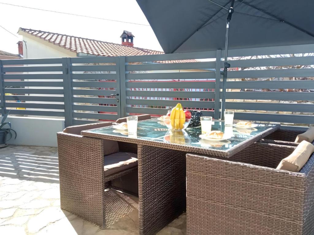 an outdoor table with an umbrella on a patio at Apartment Patrik in Vabriga