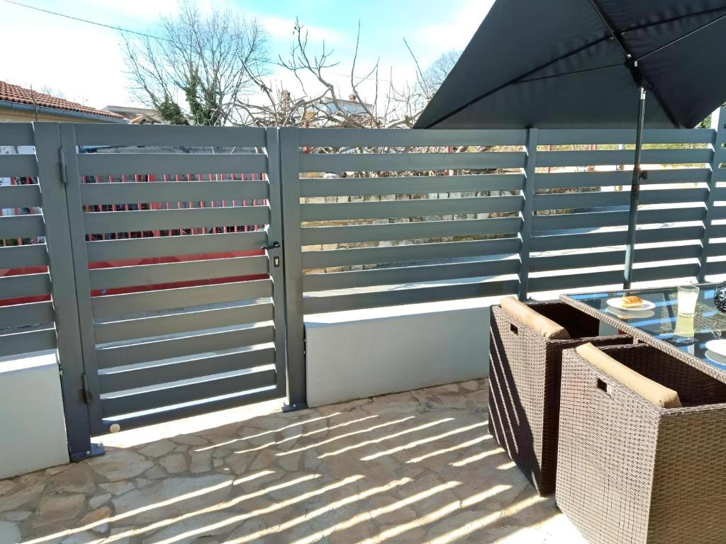 a privacy fence with a table and an umbrella at Apartment Patrik in Vabriga