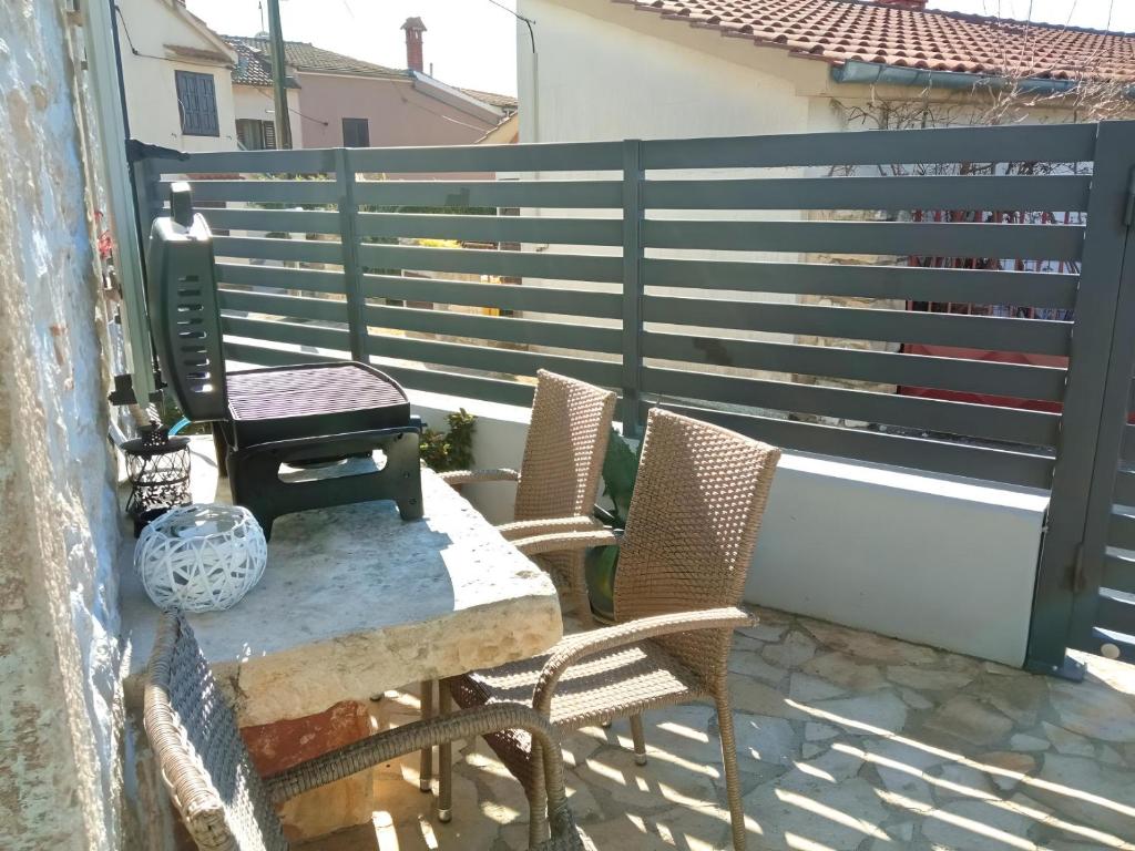 a patio with two chairs and a table and a fence at Apartment Patrik in Vabriga