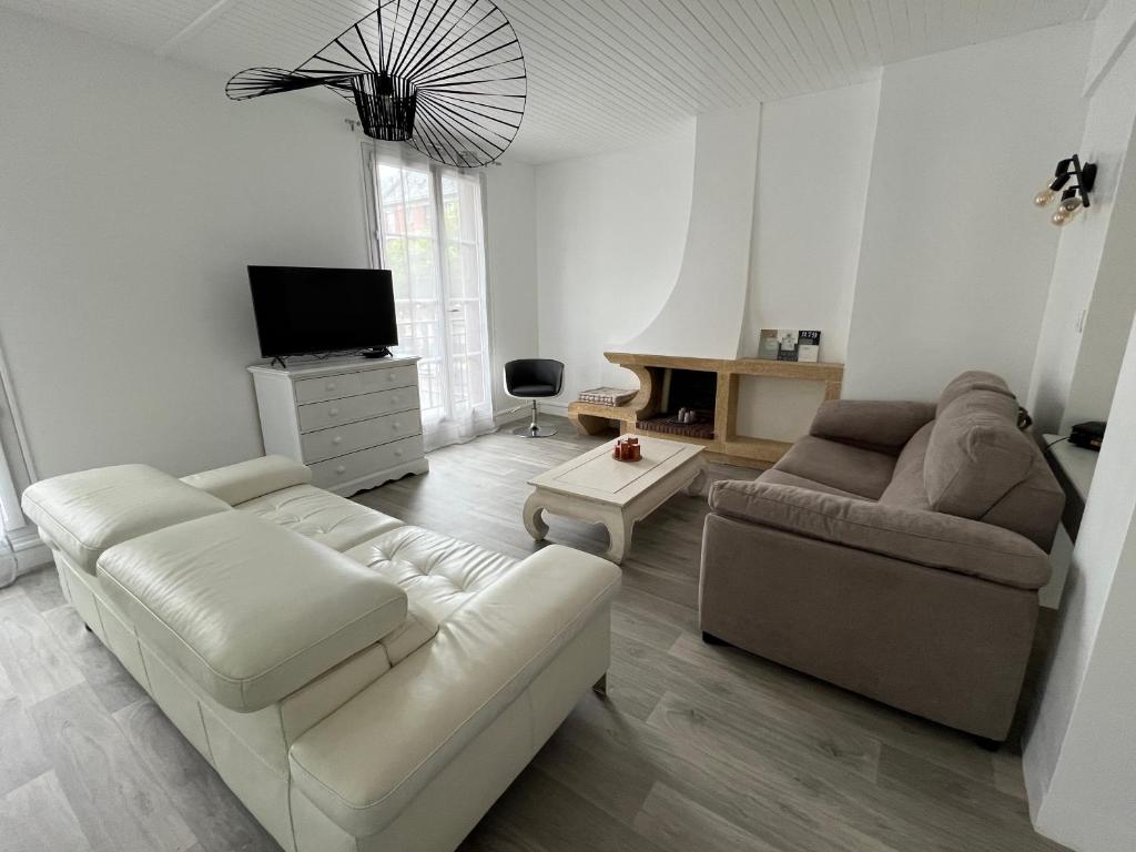 uma sala de estar com um sofá e uma televisão em Vivez au coeur Historique - St François - Grand appartement confortable em Le Havre