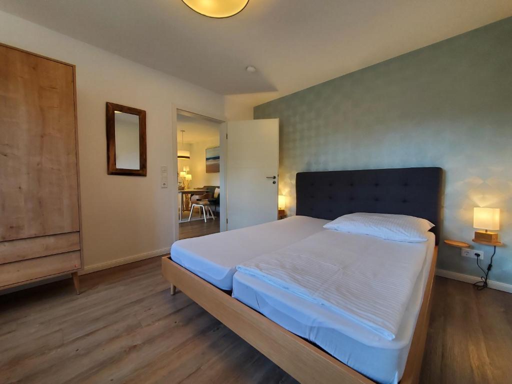 1 Schlafzimmer mit einem großen Bett und einem Esszimmer in der Unterkunft NordseeLiebe - Zeit Für Meer in Bredstedt