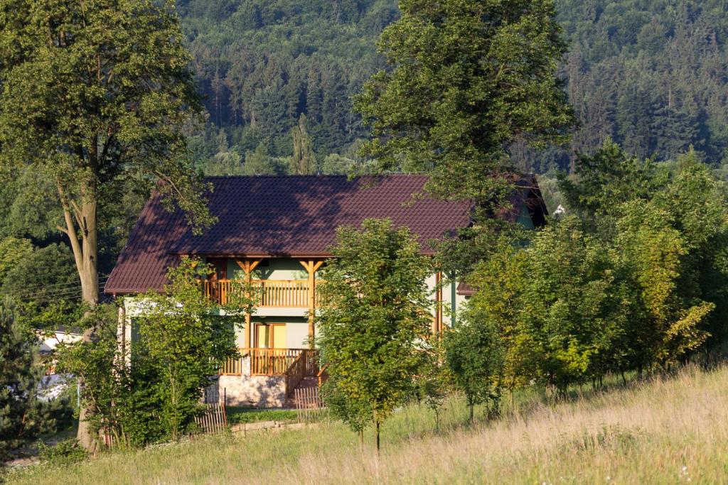 una casa en medio de un campo con árboles en Dom noclegowy „POD MNICHEM”, en Wambierzyce