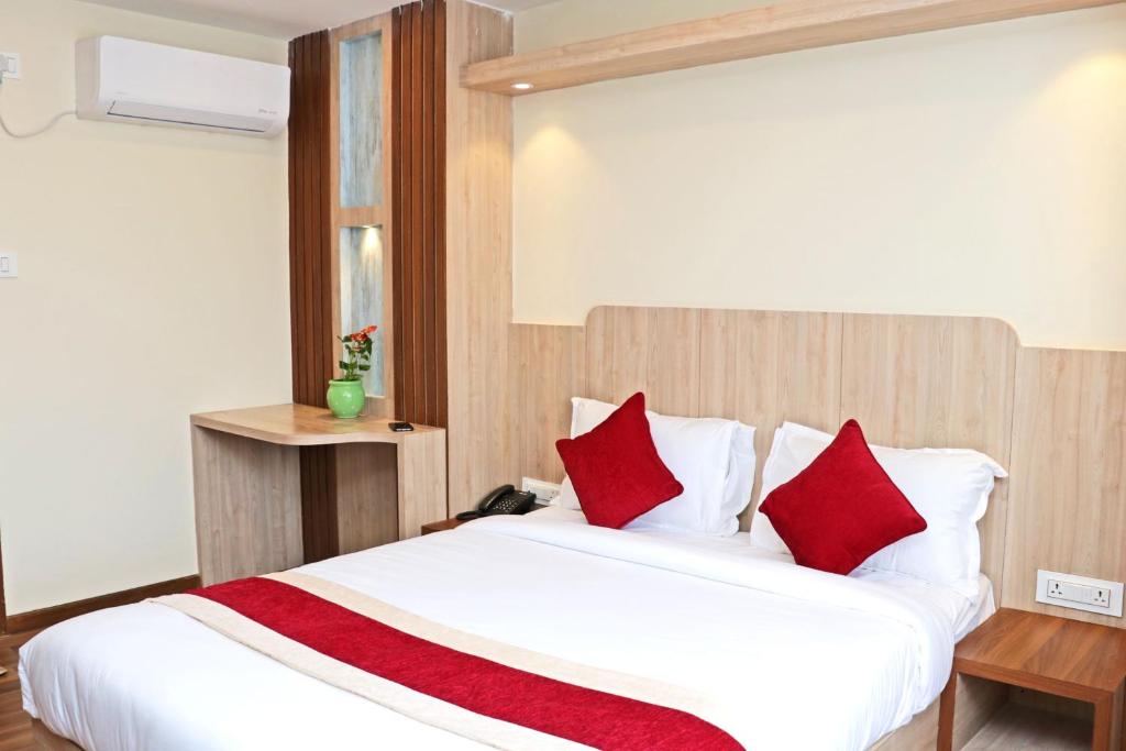 Hotel Nilakantha Pvt. Ltd في كاتماندو: غرفة نوم مع سرير أبيض كبير مع وسائد حمراء