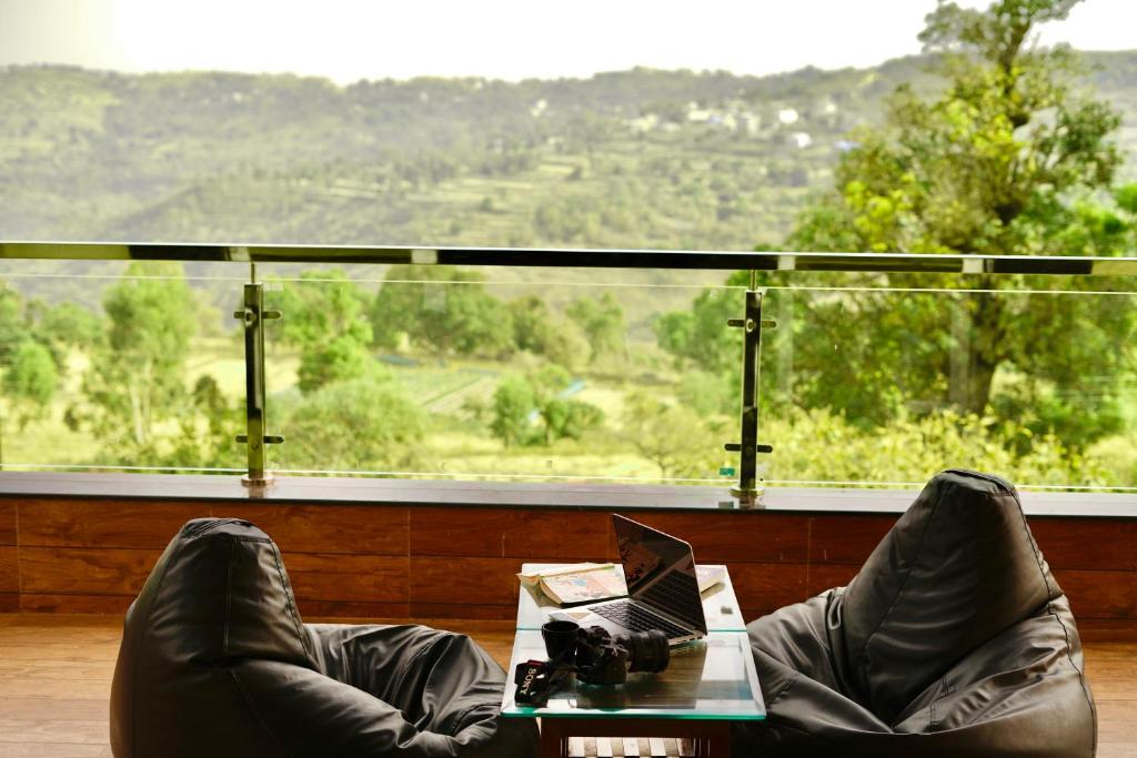 a person with their feet up on a table with a laptop at Aksha Villa in Panchgani