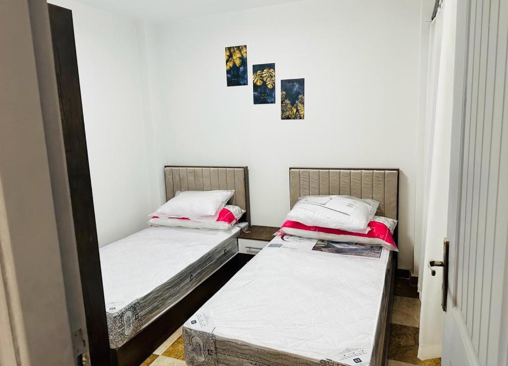 2 camas individuales en una habitación con espejo en شقه مفروش الترا سوبر لوكس مدينتى, en Madinaty