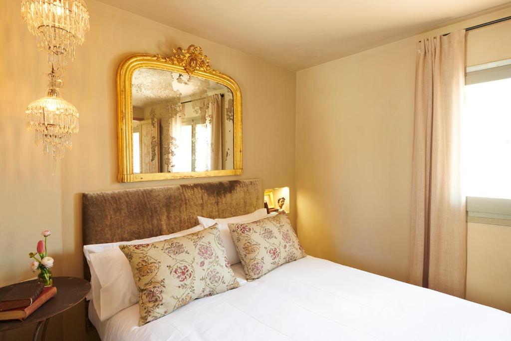 a bedroom with a white bed and a mirror at Casa Sullà in Tremp