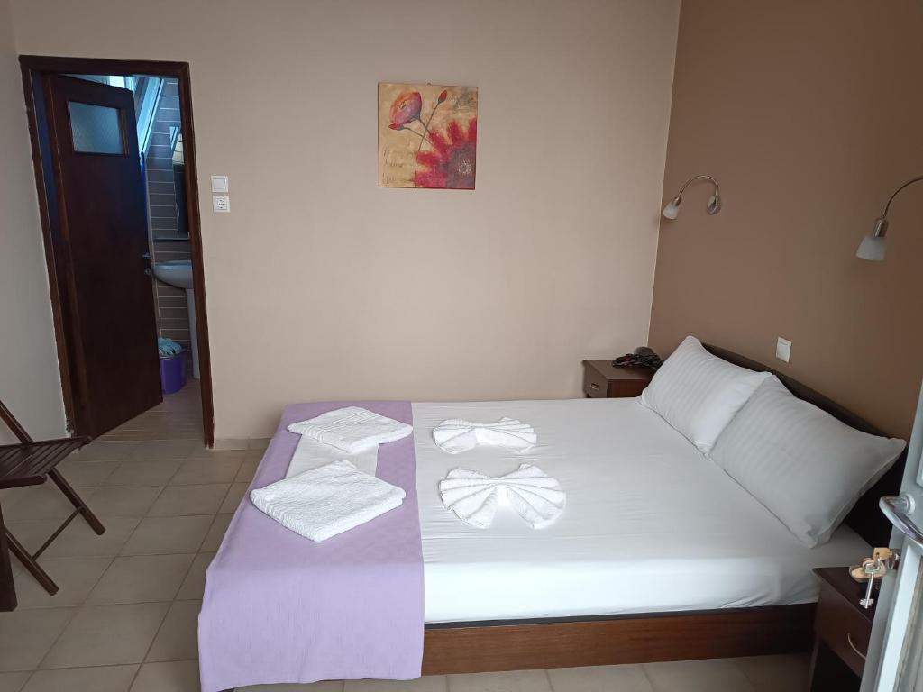 a bedroom with a bed with towels on it at GIOTAS APARTMENTS - STUDIOS in Argalasti