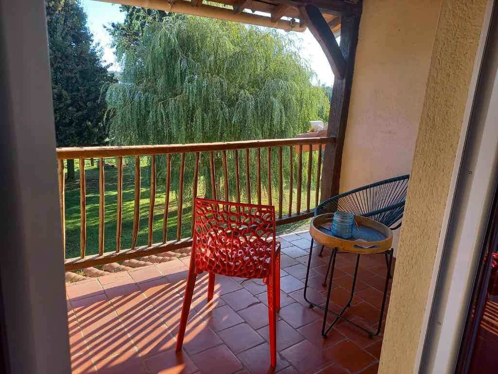 una silla roja y una mesa en el balcón en Appartement, meublé tourisme, Gîte la Maillée, en Vihiers