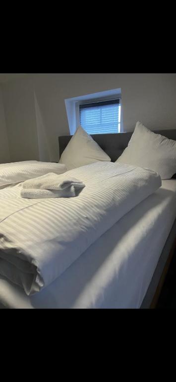 a white bed with a towel on top of it at Casa qui Piccola Eifel in Hellenthal