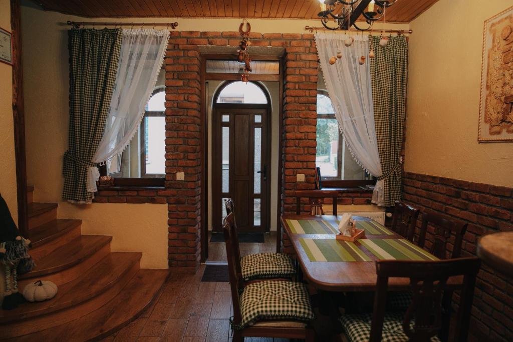 una sala da pranzo con tavolo e muro di mattoni di Dereviy a Jaremče