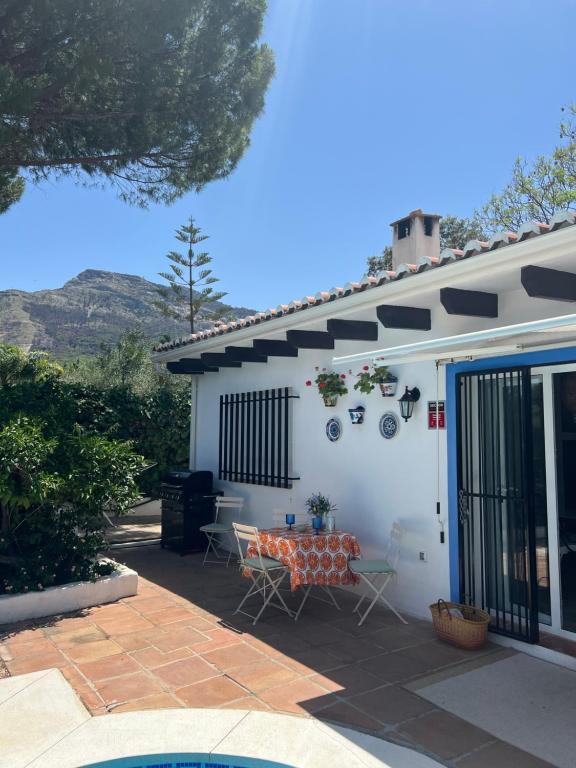 een patio met een tafel en stoelen voor een huis bij Casa Pipa Alhaurín el Grande - vrijstaande casita met privé zwembad en grote tuin in Málaga