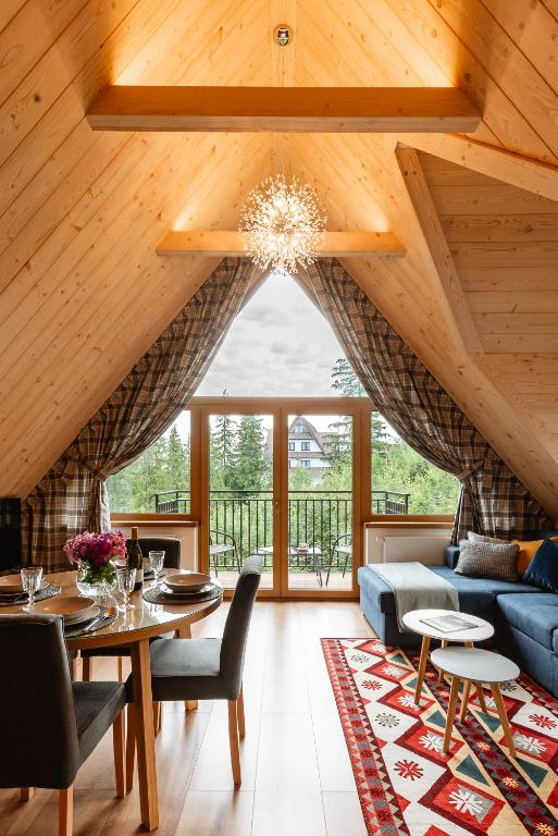 a living room with a blue couch and a table at Apartamenty Blisko TATR Zakopane in Zakopane