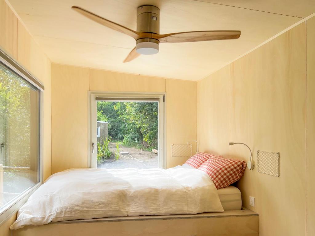 Schlafzimmer mit einem Bett und einem Deckenventilator in der Unterkunft Le repaire des impressionnistes in Amenucourt