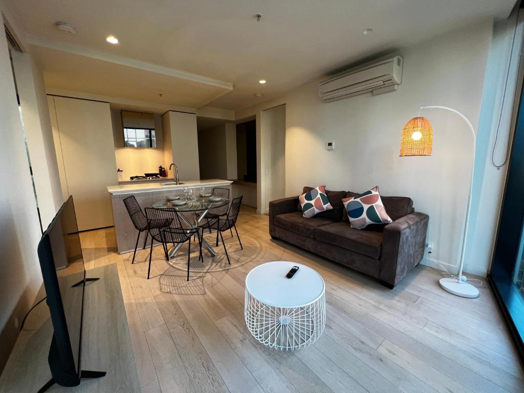 ein Wohnzimmer mit Sofa und Tisch in der Unterkunft City Central Location, Parking and 2 Bed Apartment in Melbourne