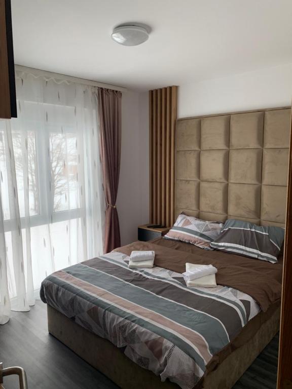 1 cama grande en un dormitorio con ventana grande en Apartman NS Zlatibor en Zlatibor