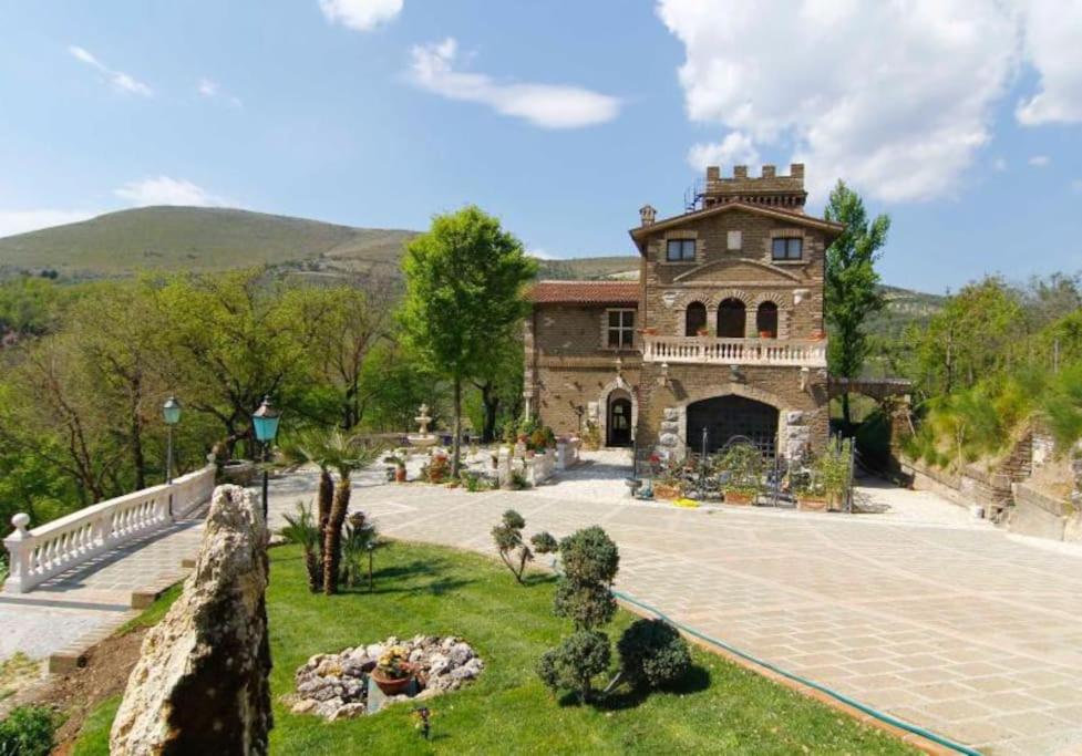 une grande maison avec un jardin en face de celle-ci dans l'établissement Prestigioso Casale Castello Alma, à Ponticelli