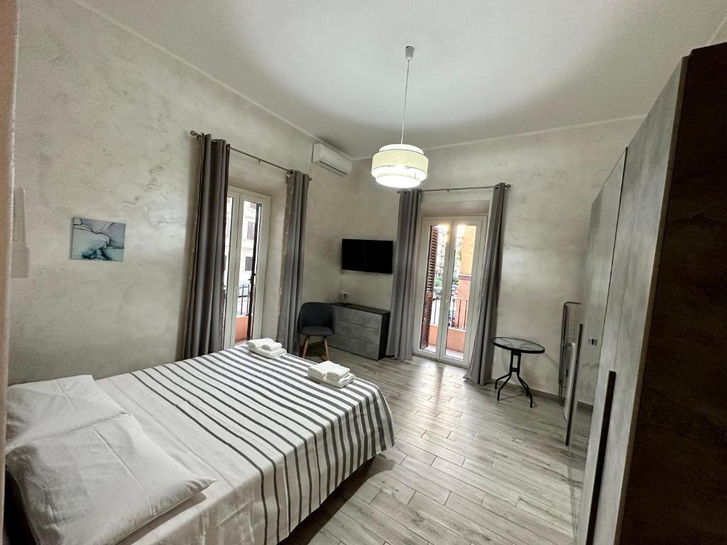 Schlafzimmer mit einem Bett, einem Schreibtisch und einem TV in der Unterkunft NEWHOUSE ANTIUM in Anzio