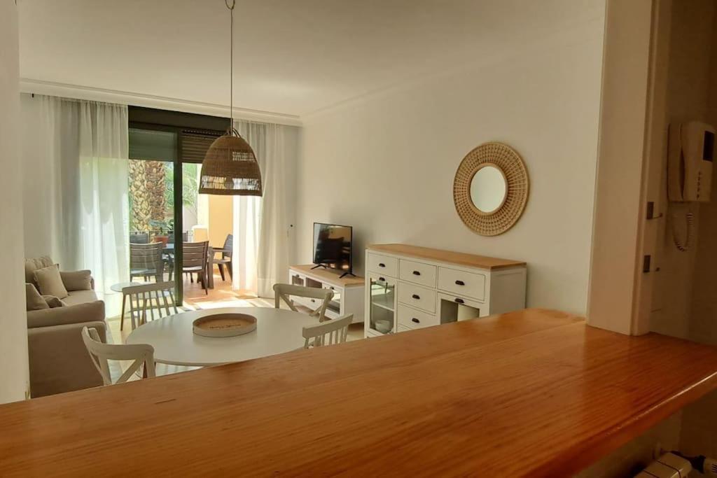 cocina y sala de estar con mesa y sofá en Bonito ático en Roda Golf en San Javier