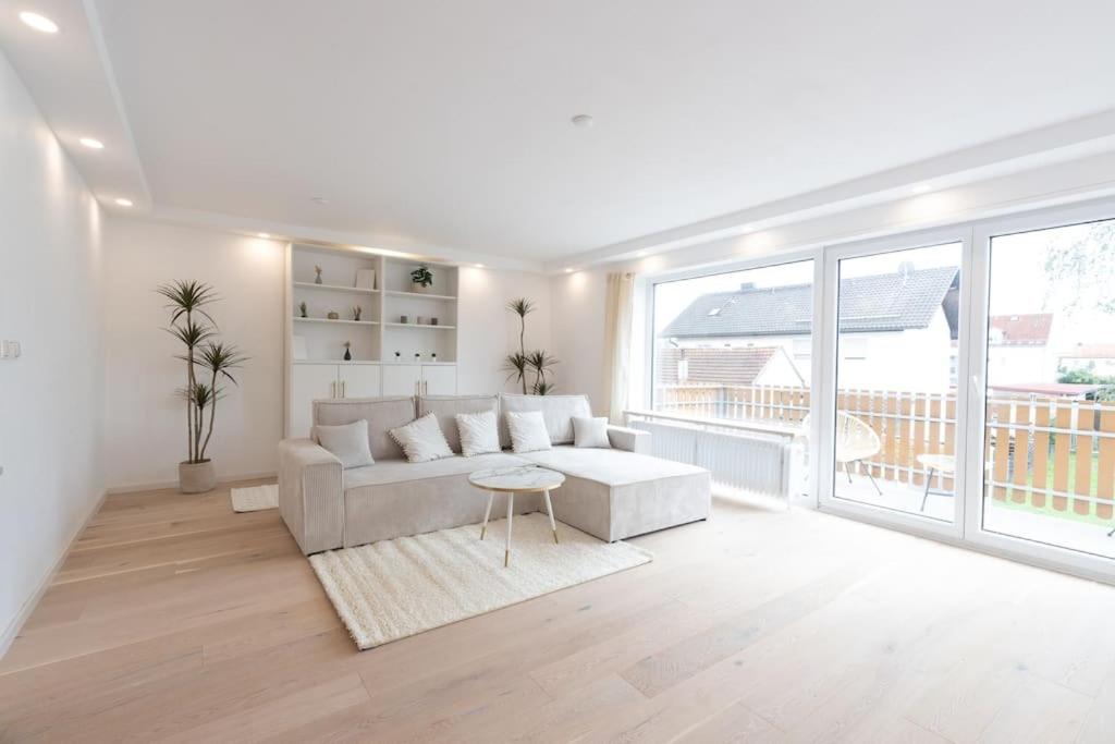 a white living room with a couch and a large window at Stylish Apartment near Munich in Moorenweis